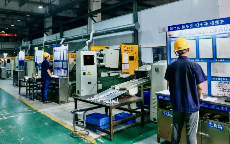 Factory floor with workers operating machinery, emphasizing teamwork and operational capability in contract manufacturing.