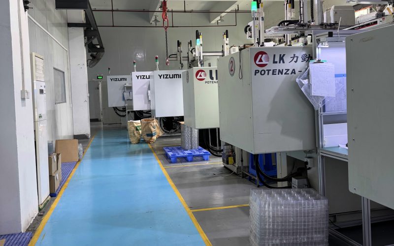 Injection molding machines in a clean, organized contract manufacturing facility with LK and Yizumi branded equipment.