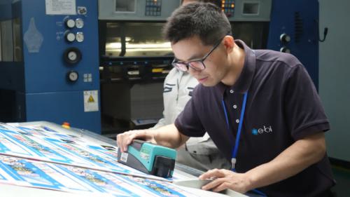 Sam, of the printing & packaging team, inspects a print job for quality.